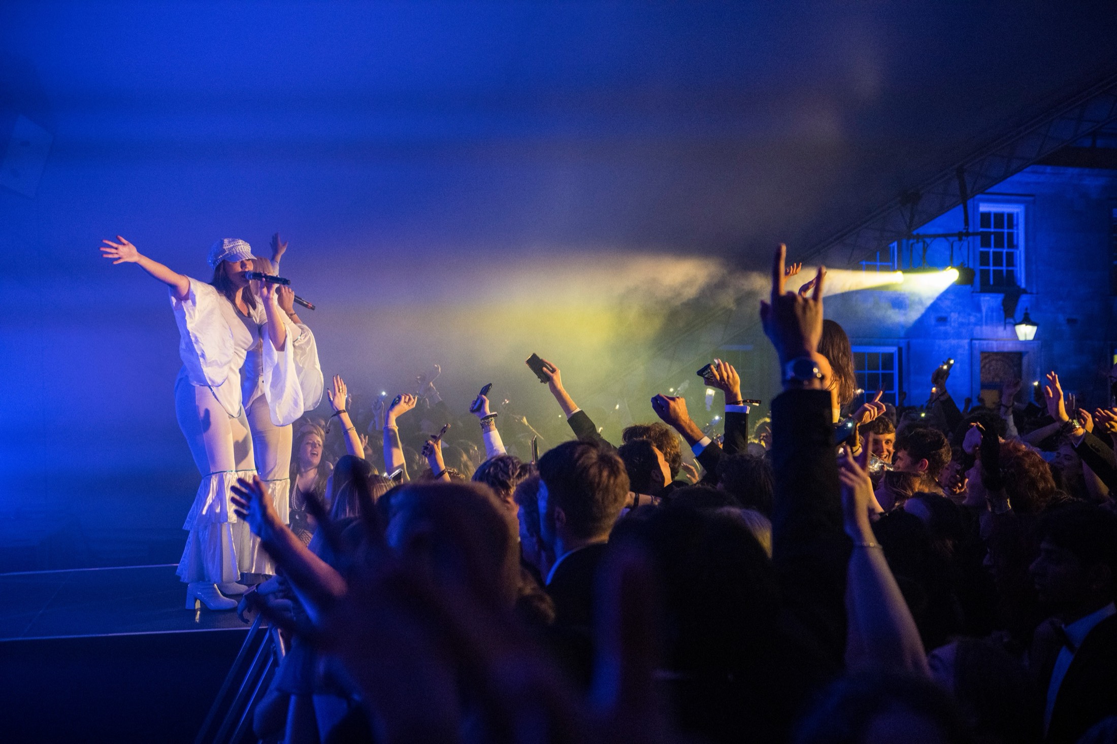 The Soul of ABBA on stage with arms outstretched as a packed crowd raises their hands