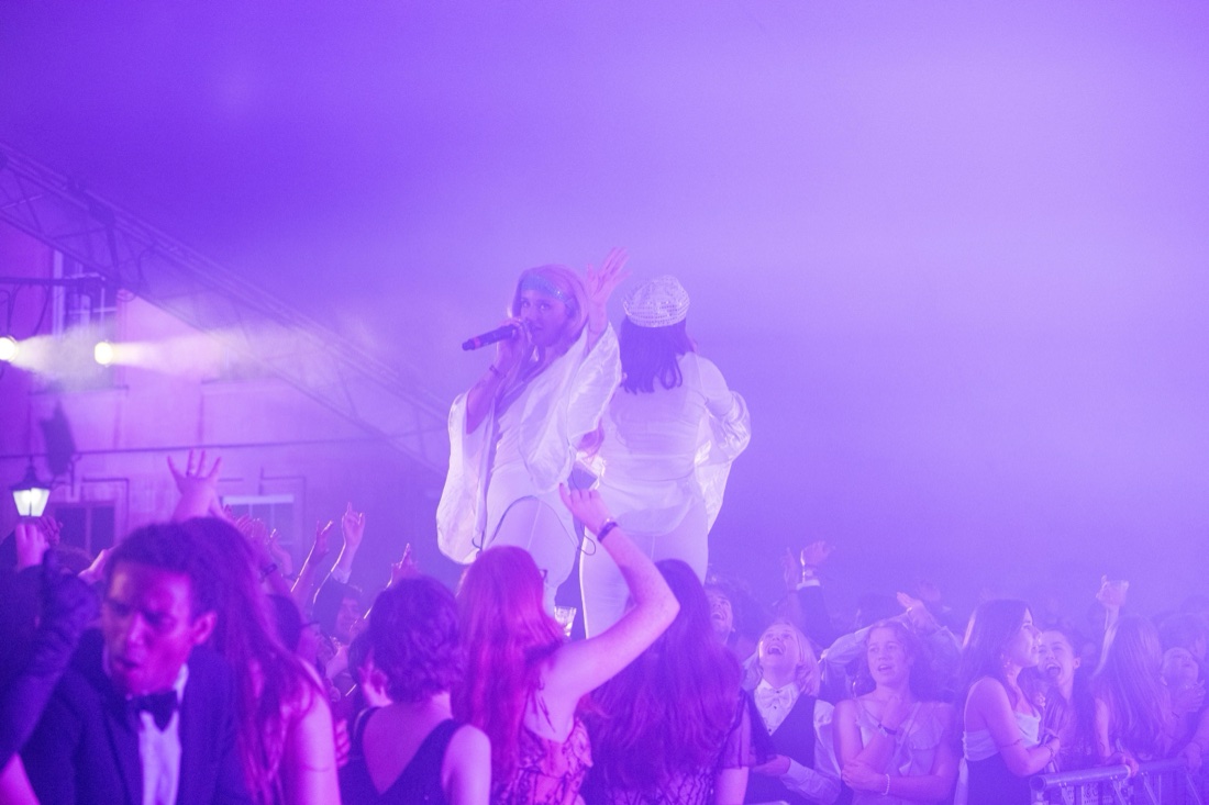 Black-tie ball guests crowding the front of the stage at night